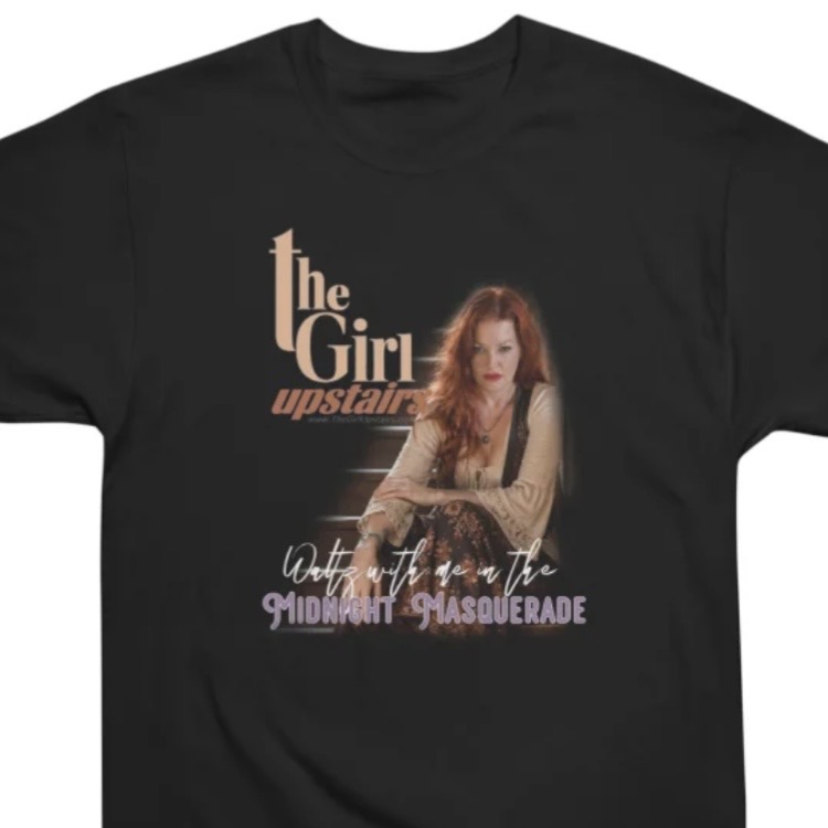 Black T-shirt featuring “The Girl Upstairs” text and a seated red-haired woman graphic.