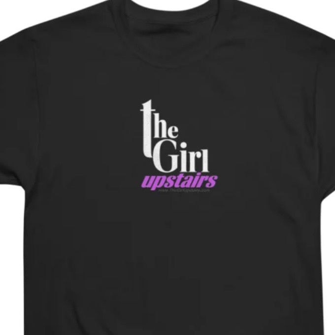 Black T-shirt featuring “The Girl Upstairs” logo with a purple text design.